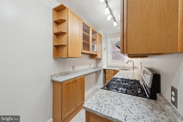 kitchen featuring a sink, gas range, baseboards, open shelves, and light stone countertops