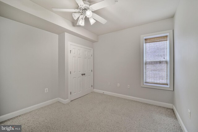 unfurnished bedroom with baseboards, carpet flooring, and a closet