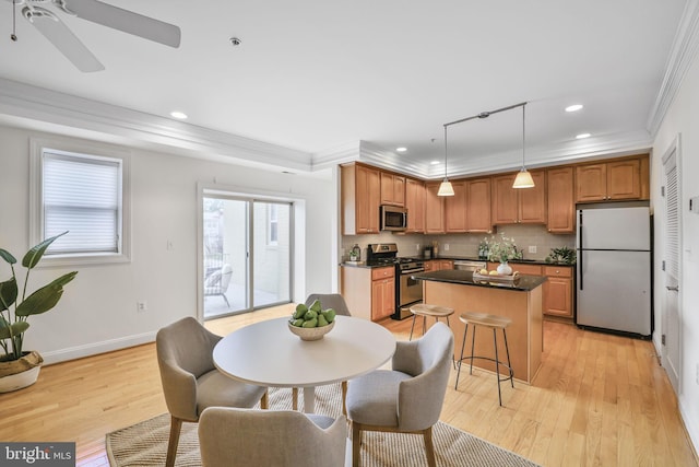 dining space with ornamental molding, light wood-type flooring, recessed lighting, baseboards, and a ceiling fan