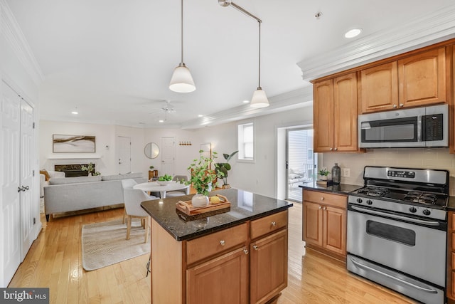 kitchen featuring appliances with stainless steel finishes, crown molding, recessed lighting, ceiling fan, and dark stone countertops