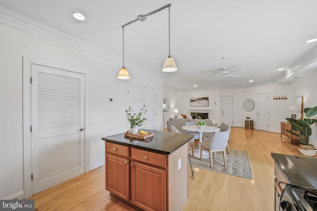 kitchen with a ceiling fan, light wood finished floors, range, ornamental molding, and recessed lighting