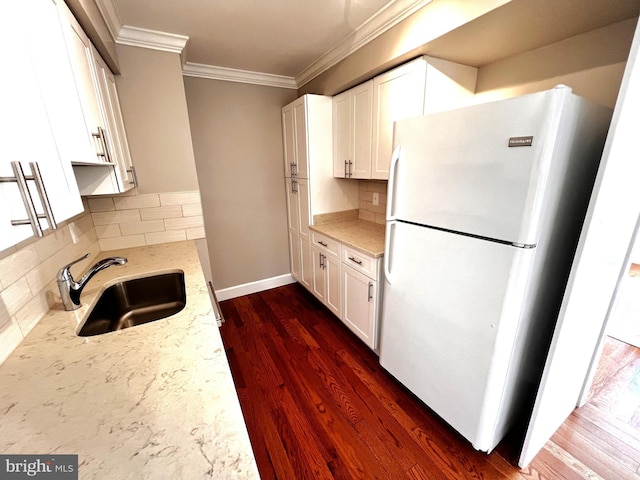 6572 Flagmaker Ct, Falls Church, VA 22042 - kitchen featuring freestanding refrigerator, a sink, crown molding, light stone counters, and white cabinetry