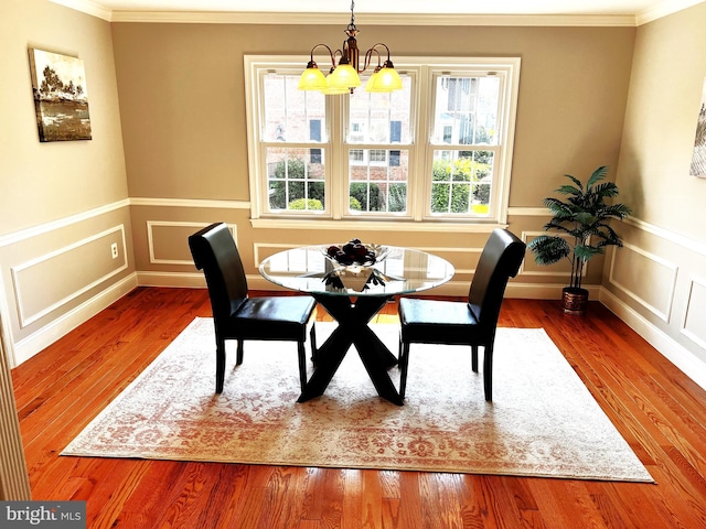 6572 Flagmaker Ct, Falls Church, VA 22042 - dining area with ornamental molding, a chandelier, wood finished floors, a wainscoted wall, and a decorative wall