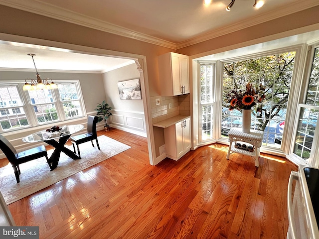 6572 Flagmaker Ct, Falls Church, VA 22042 - dining room with a chandelier, ornamental molding, light wood-style floors, wainscoting, and a decorative wall