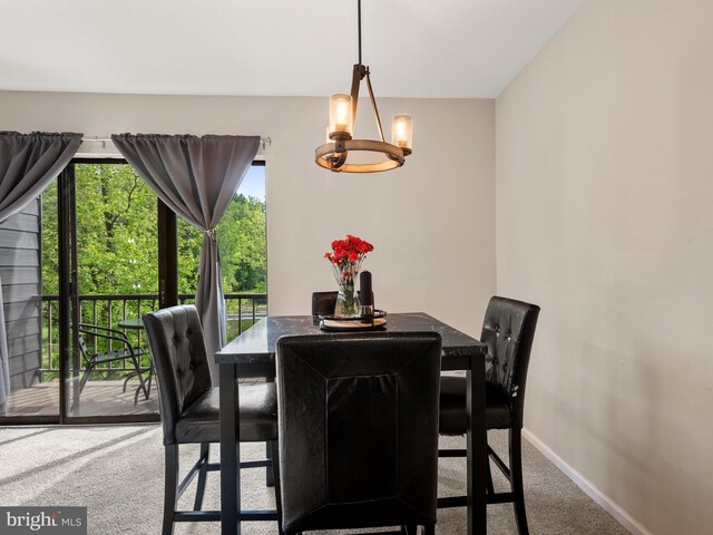 dining area featuring carpet floors, a chandelier, and baseboards