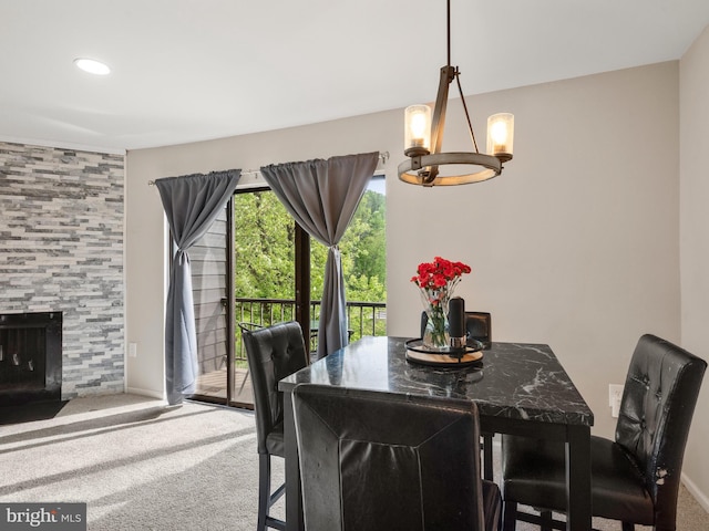 carpeted dining space with a chandelier, recessed lighting, and a tiled fireplace