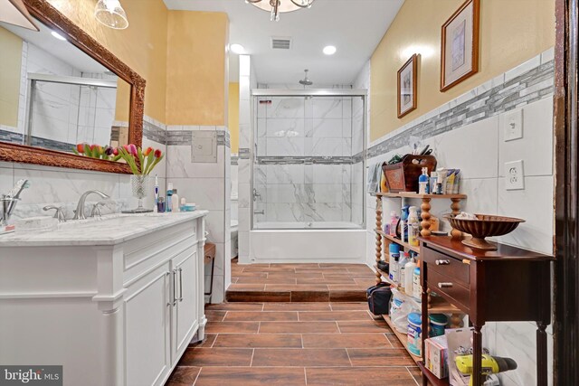 226 S 5th St, Reading, PA 19602 - bathroom featuring tile walls, wood tiled floors, a combined bath / shower with rainfall shower, vanity, and toilet