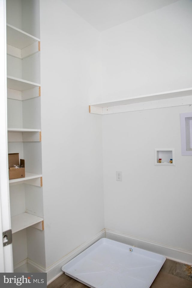 clothes washing area featuring hookup for a washing machine, baseboards, and wood finished floors