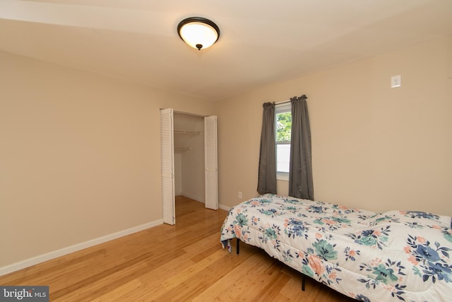bedroom featuring light wood-style flooring, a closet, and baseboards