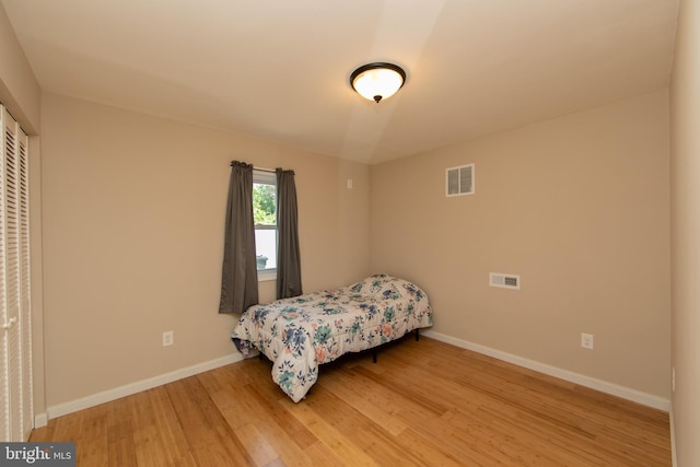 bedroom with light wood-type flooring and baseboards