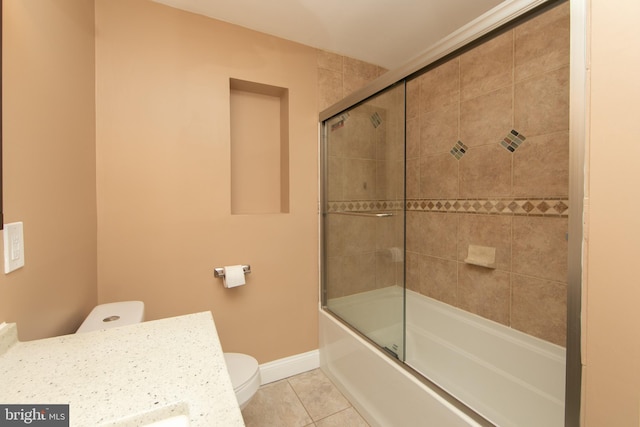 bathroom with tile patterned flooring, toilet, baseboards, shower / bath combination with glass door, and vanity