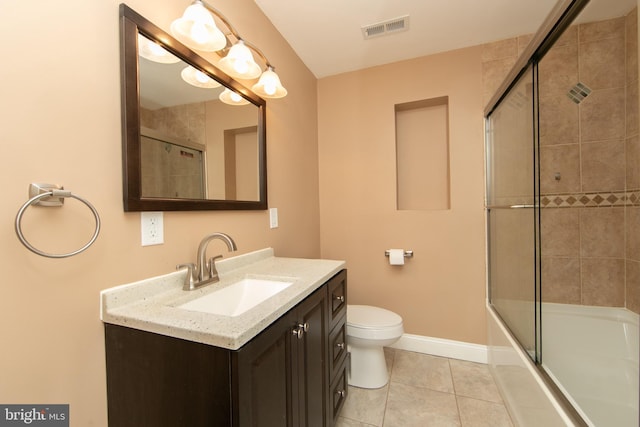 bathroom featuring vanity, tile patterned floors, baseboards, toilet, and combined bath / shower with glass door