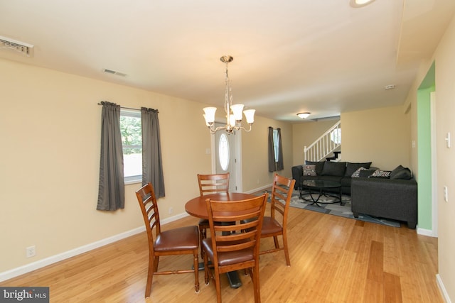 dining area featuring light wood-style flooring, stairway, and healthy amount of natural light