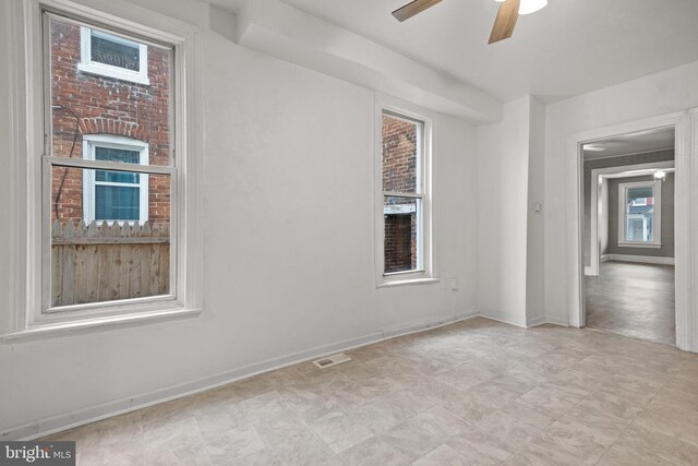 unfurnished room featuring ceiling fan and baseboards