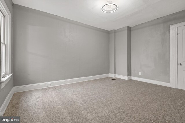 unfurnished room with carpet and baseboards