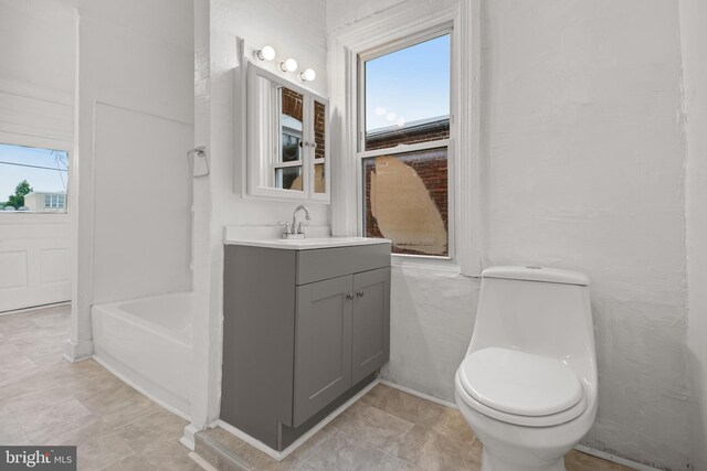 full bath featuring toilet, vanity, and a tub to relax in