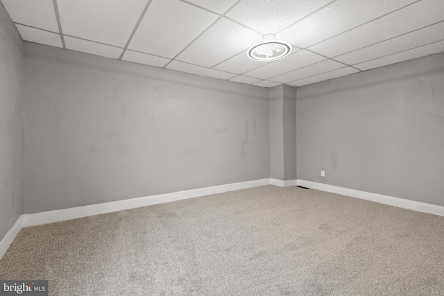 unfurnished room with carpet flooring, a drop ceiling, and baseboards