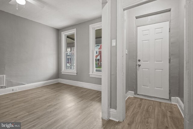 entryway featuring wood finished floors, ceiling fan, and baseboards