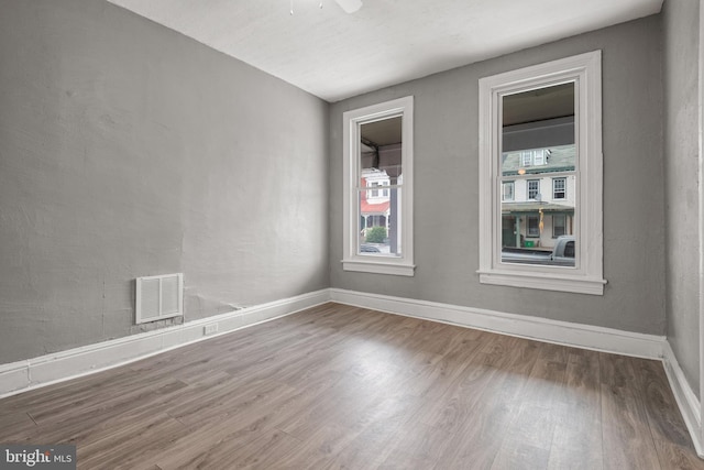 unfurnished room featuring wood finished floors, baseboards, and a ceiling fan