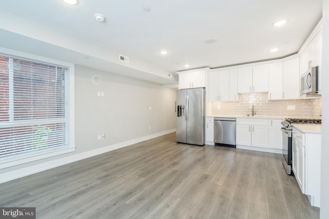 1309 S 52nd St, Philadelphia, PA 19143 - kitchen featuring appliances with stainless steel finishes, baseboards, a sink, backsplash, and light countertops