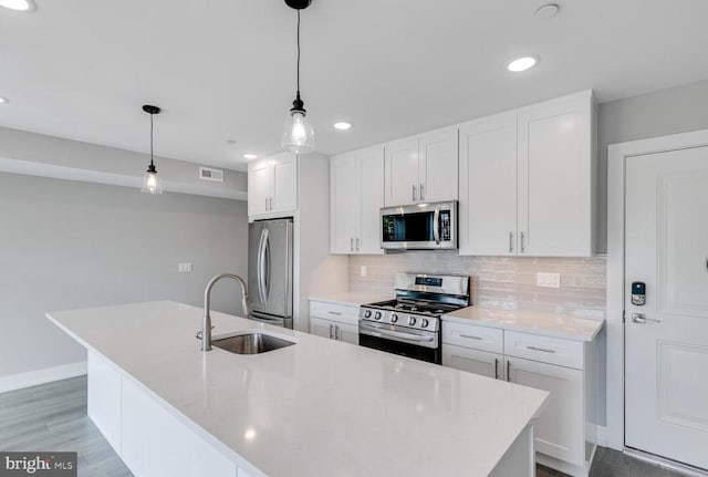 1309 S 52nd St, Philadelphia, PA 19143 - kitchen featuring stainless steel appliances, a sink, backsplash, white cabinets, and recessed lighting