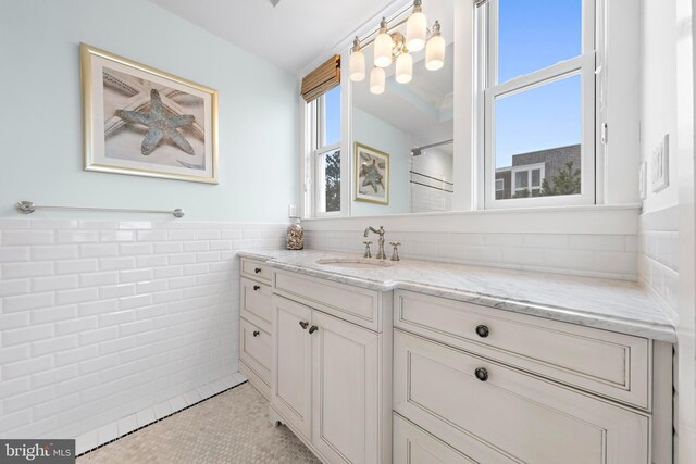 6601 Ocean Blvd, Long Beach Township, NJ 08008 - bathroom with tile walls, vanity, tile patterned floors, a wainscoted wall, and a chandelier