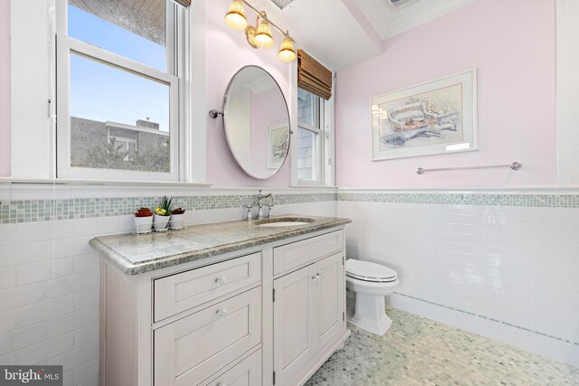 6601 Ocean Blvd, Long Beach Township, NJ 08008 - bathroom with tile walls, a wainscoted wall, toilet, and vanity