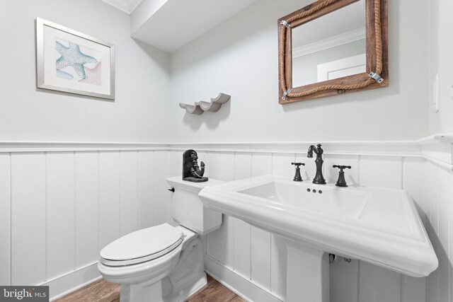 6601 Ocean Blvd, Long Beach Township, NJ 08008 - half bathroom with wood finished floors, toilet, wainscoting, a sink, and crown molding