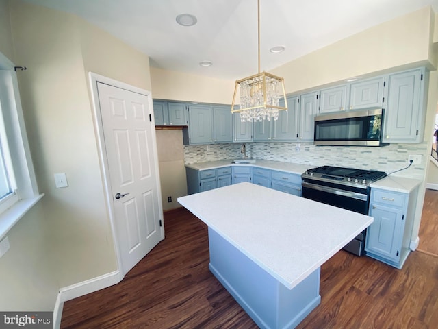 976 Klockner Rd, Hamilton Township, NJ 08619 - kitchen featuring appliances with stainless steel finishes, blue cabinets, a chandelier, dark wood-style floors, and light countertops