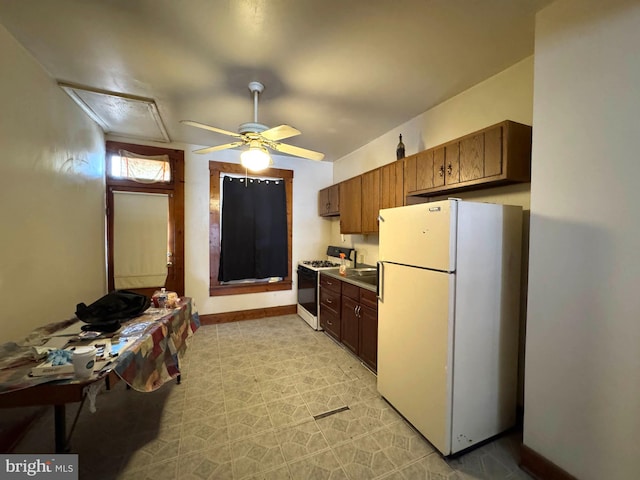 1332 Sargeant St, Baltimore, MD 21223 - kitchen with freestanding refrigerator, range with gas stovetop, a ceiling fan, and a sink
