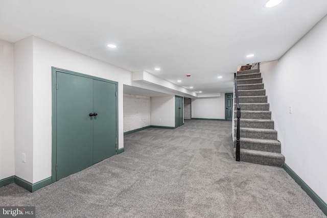 finished below grade area featuring carpet, baseboards, stairway, and recessed lighting