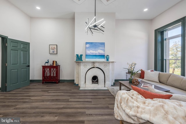 living room with dark wood-style flooring, a chandelier, recessed lighting, baseboards, and a high ceiling