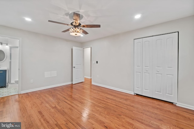 unfurnished bedroom with light wood-style flooring, baseboards, a closet, recessed lighting, and ensuite bathroom