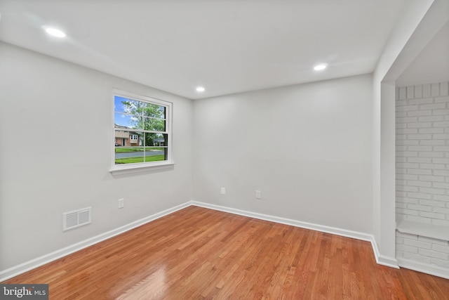 empty room with wood finished floors, baseboards, and recessed lighting