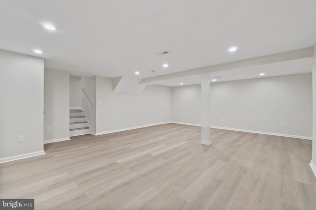 finished below grade area featuring recessed lighting, light wood-style flooring, stairway, and baseboards