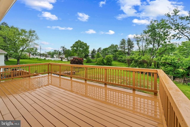 wooden terrace featuring a lawn