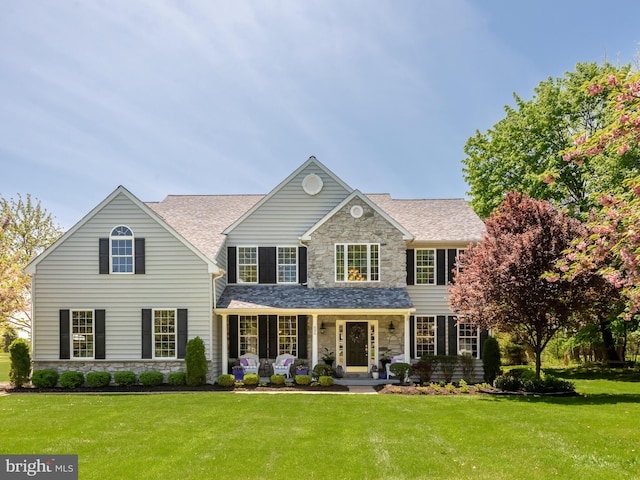 606 Borough Line Rd, Collegeville, PA 19426 - view of front of house featuring stone siding, covered porch, a front lawn, and a shingled roof