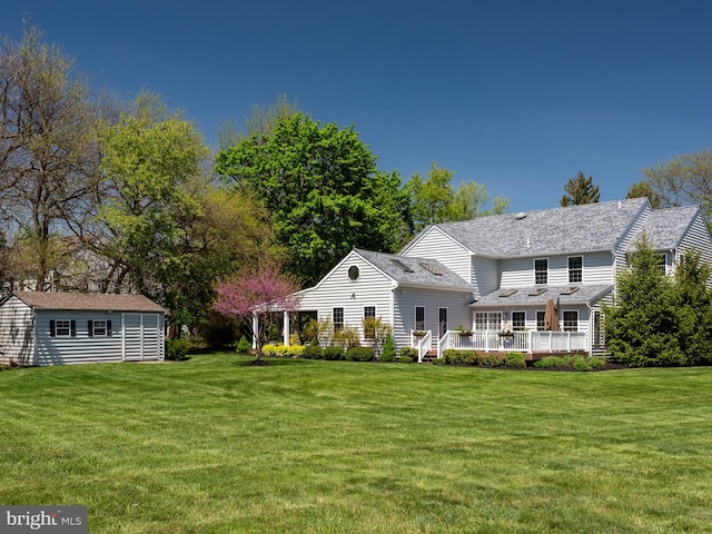 606 Borough Line Rd, Collegeville, PA 19426 - view of front facade with an outdoor structure, a front lawn, a deck, and a shingled roof