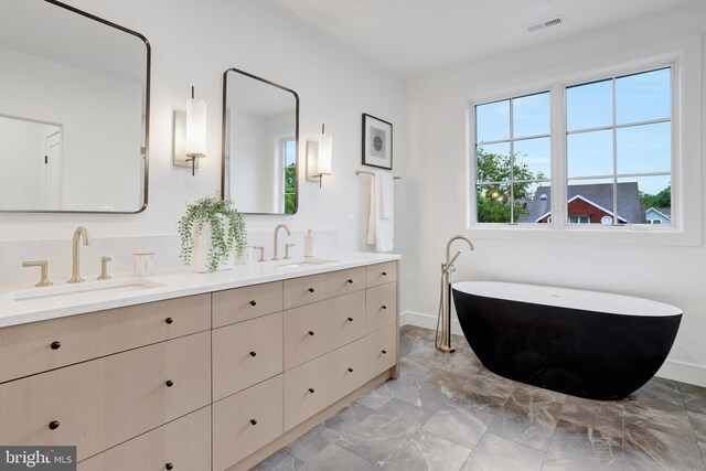 1416 N Hancock St, Arlington, VA 22201 - full bathroom featuring marble look tile flooring, double vanity, a soaking tub, and baseboards
