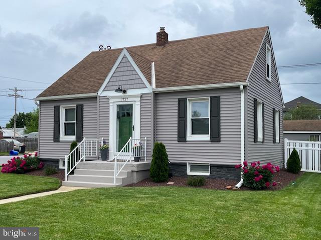 view of front facade featuring a chimney and roof with shingles