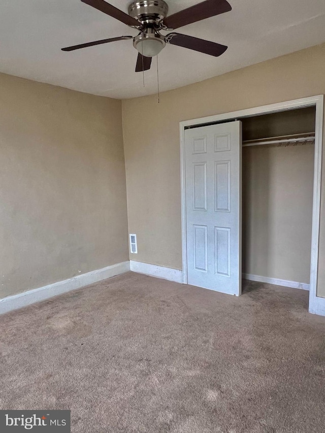 unfurnished bedroom with carpet flooring, a closet, a ceiling fan, and baseboards