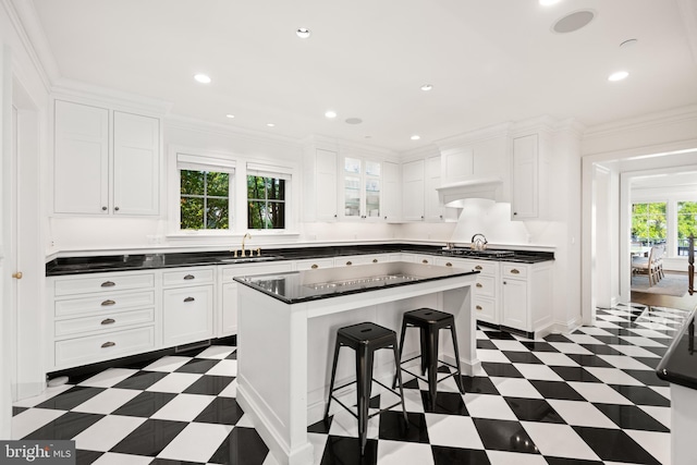 17 Revell St, Annapolis, MD 21401 - kitchen featuring dark flooring, dark countertops, white cabinets, a breakfast bar area, and a center island