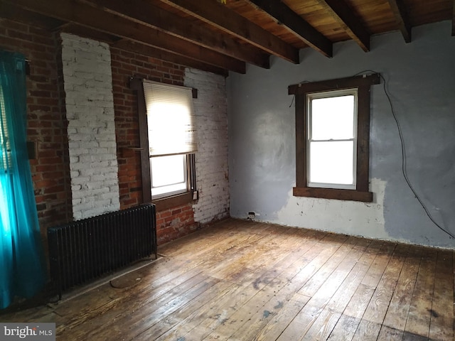 spare room with beamed ceiling, hardwood / wood-style floors, radiator heating unit, and wood ceiling