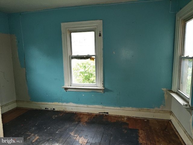unfurnished room featuring hardwood / wood-style flooring, healthy amount of natural light, and baseboards