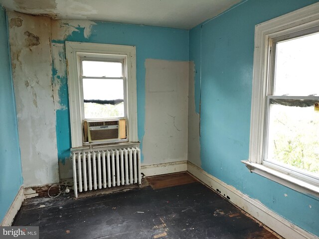 spare room featuring radiator heating unit and cooling unit