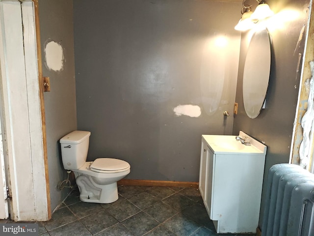 half bath featuring radiator heating unit, toilet, tile patterned floors, vanity, and baseboards