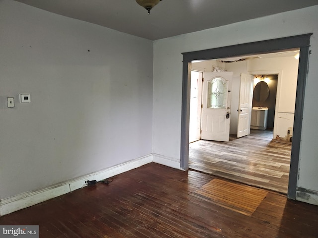 unfurnished room featuring wood-type flooring and baseboards