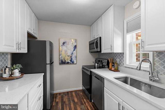 1716 W Abingdon Dr Unit 103, Alexandria, VA 22314 - kitchen featuring appliances with stainless steel finishes, a sink, dark wood-style flooring, white cabinetry, and tasteful backsplash