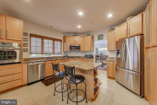 13605 Autumn End Ter, Laurel, MD 20707 - kitchen with appliances with stainless steel finishes, light brown cabinets, a center island, a kitchen breakfast bar, and a sink