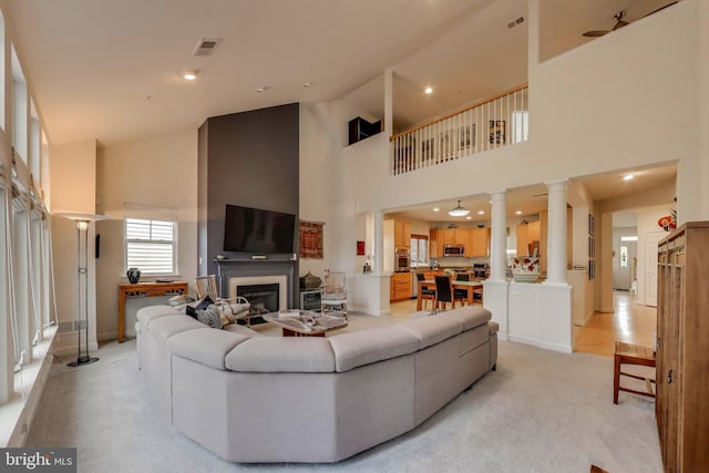 13605 Autumn End Ter, Laurel, MD 20707 - living area with ornate columns, high vaulted ceiling, a glass covered fireplace, baseboards, and light colored carpet